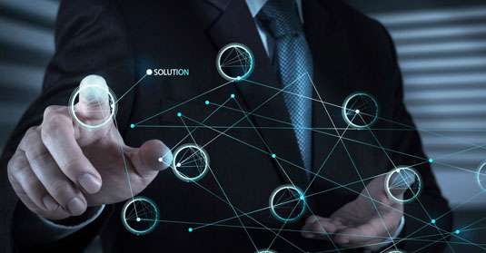 Chandra Technologies Inc. A man in a suit and tie holding a smart phone.